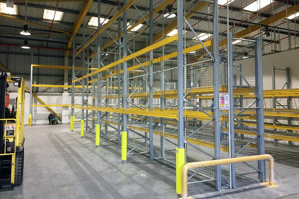 Newly installed pallet racking racking with full upright protection and anti-collapse mesh walkway space to allow fork lift access